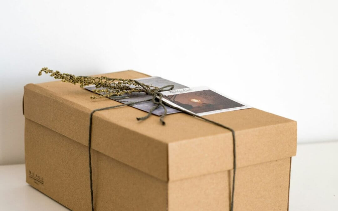 “A simple brown memory box tied with string, holding small keepsakes and photos — symbolizing the tender moments mothers want to remember during early postpartum.”