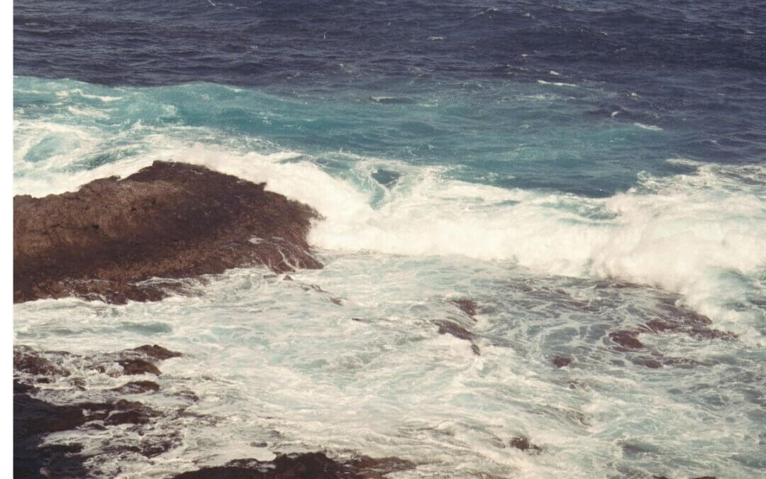 Waves crashing against a rocky shoreline representing chronic stress and overfunctioning in women